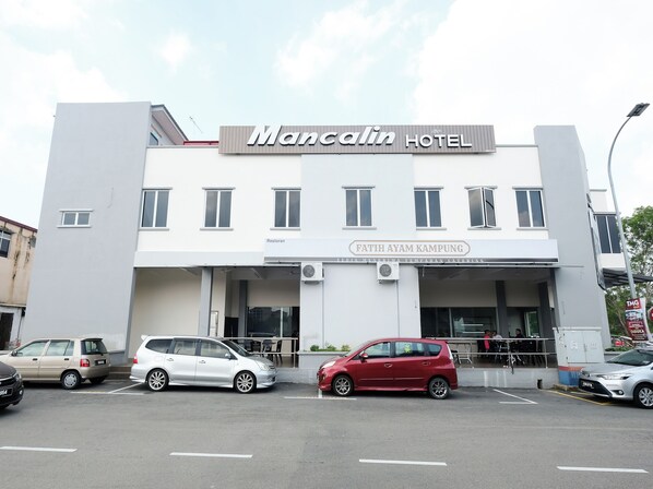 A hotel with a sign reading "Mancalin Hotel" and "Fathiah Ayam Kampung" below it.