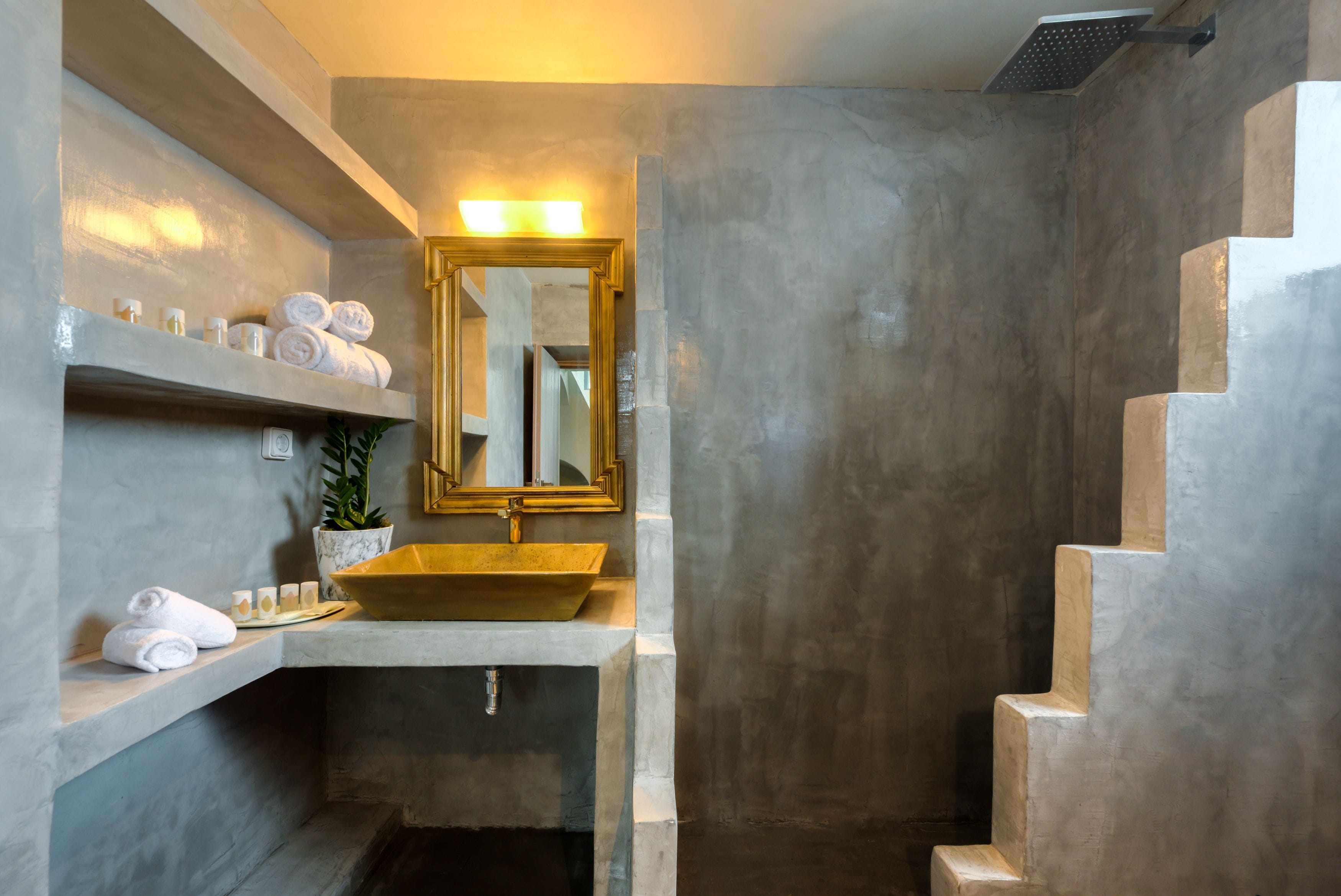 A bathroom with a large mirror, a sink, and a shower area.