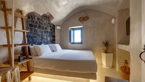 A bedroom with a stone wall, a wooden ladder, a bed, a window, and a potted plant. - Pasithea Luxury Suites (Santorini)