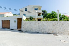 Ein modernes Haus mit zwei Etagen, einer Steinwand, einer Garage und einem Balkon.