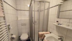 Kylpyhuoneessa on lasiseinällä varustettu suihku, wc, pesuallas ja pyyhekoukku.