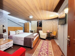 A hotel room with a bed, a desk, a chair, a small table, and a TV mounted on the wall. - The New Season Apart (Istanbul)