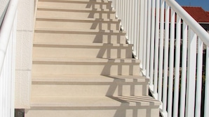 A set of beige stairs with white railings leading up to a building entrance. - Apartments Magda (Supetar)