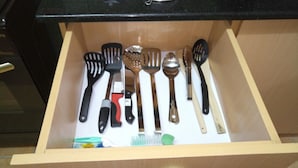 A drawer with various kitchen utensils including spatulas, a spoon, and a brush. - Scenic View Apartments Kilimani (Nairobi)