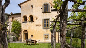 A rustic building with a stone facade, arched windows, and a small balcony. - Villa Barsotti (Pescaglia)