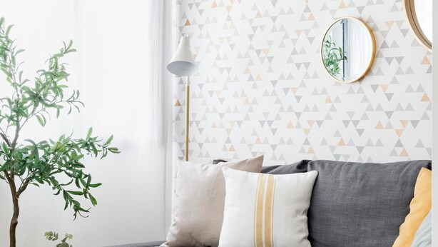A modern living room with a grey sofa, white side table, and a potted plant. - Go Madrid Apartments by Olala Homes (Madrid)