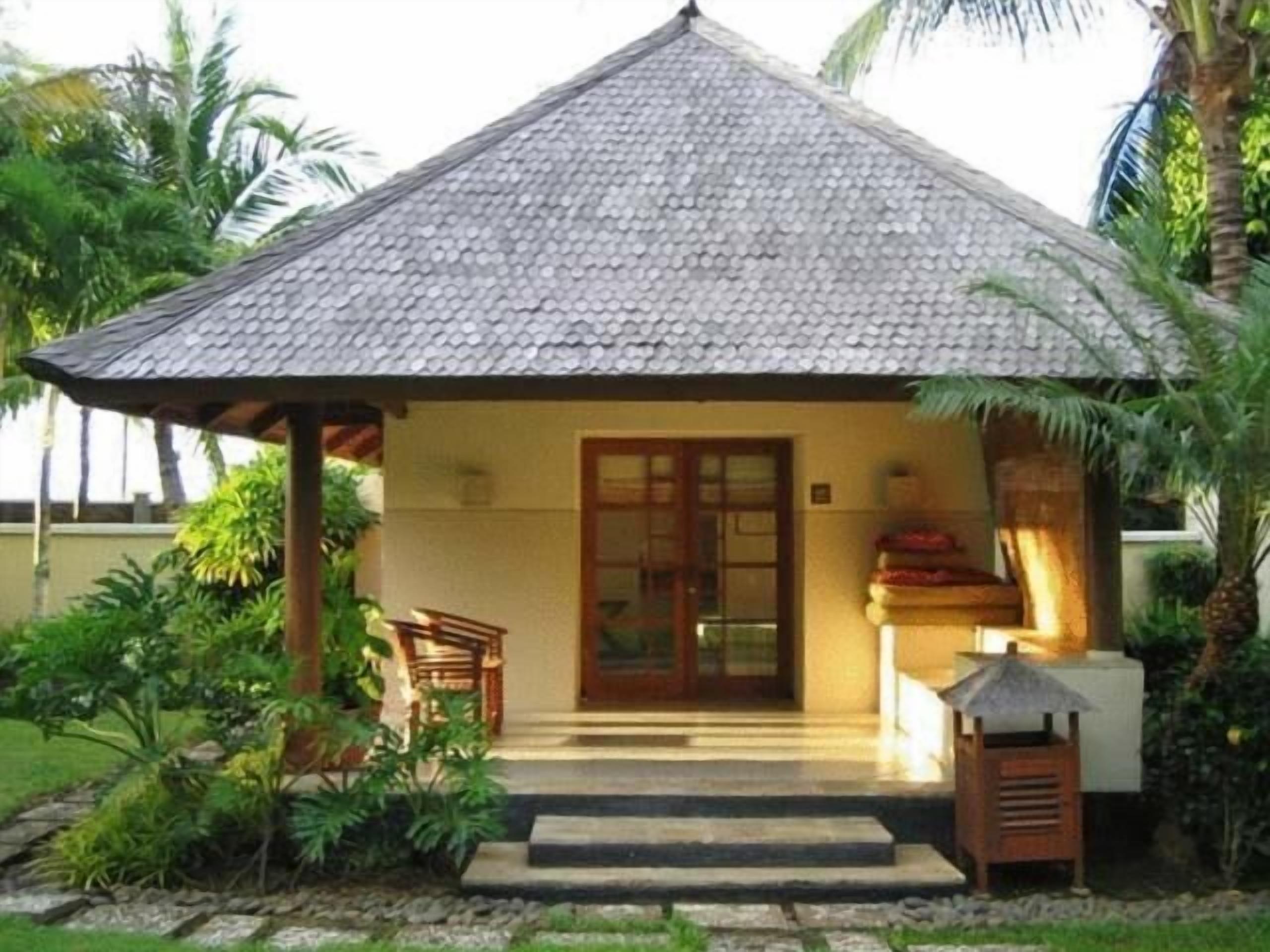 A small, single-story building with a tiled roof, a wooden porch, and a door.