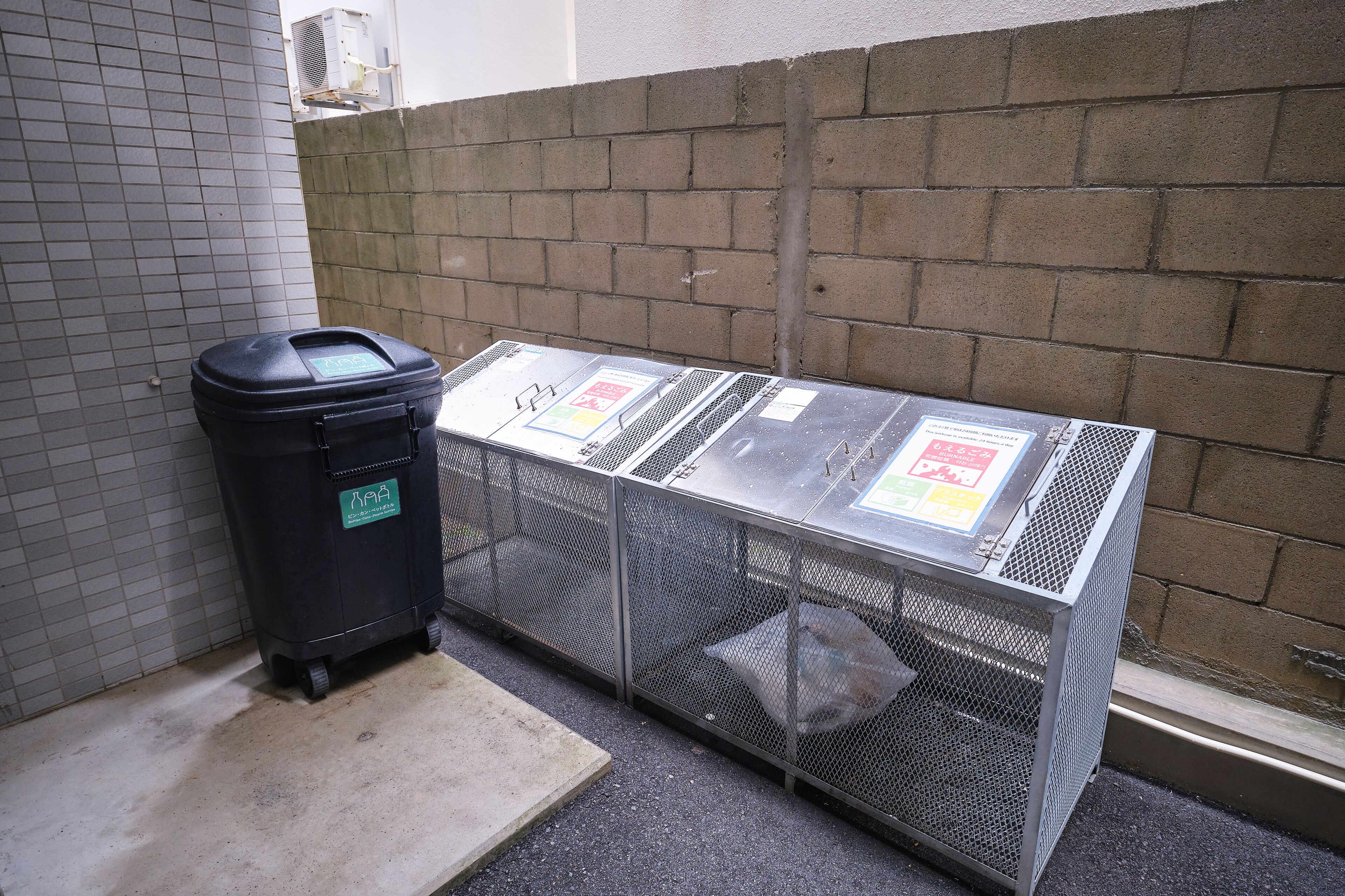 A utility room with a trash bin and metal cages, likely for maintenance or storage.