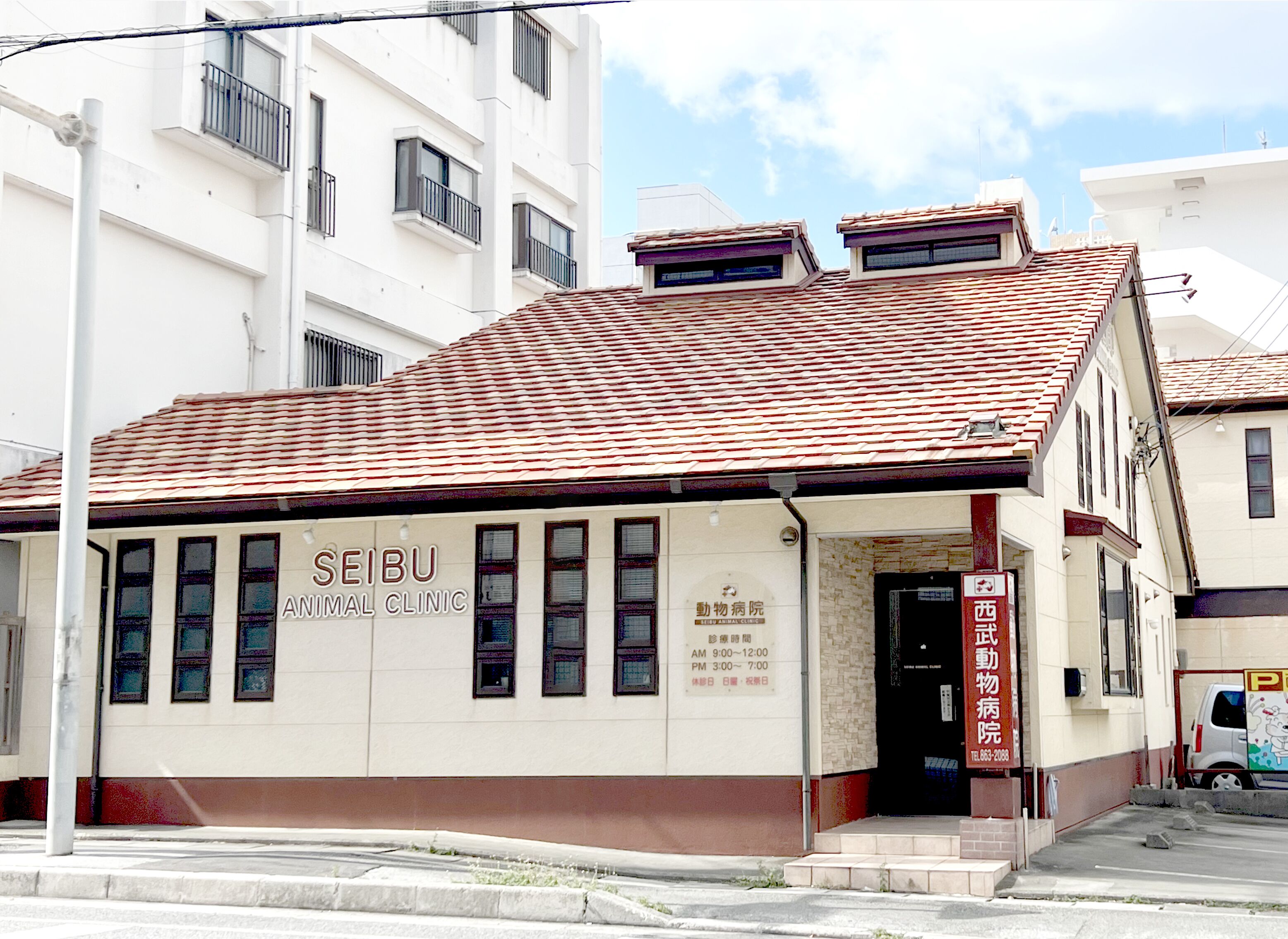A building with a tiled roof and signage for a Seibu Animal Clinic.