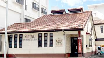 A building with a tiled roof and signage for a Seibu Animal Clinic.