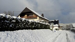 A snow-covered road leading to a house with a sloped roof and wooden balcony. - Zur schönen Aussicht (Hellenthal)