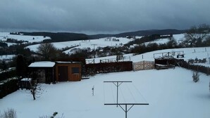 A rural landscape with a small wooden structure, possibly a shed, and a metal fence. - Zur schönen Aussicht (Hellenthal)