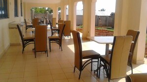 A spacious indoor dining area with high ceilings and large windows, featuring multiple tables and chairs. - Siaya Summit Hotel (Siaya)