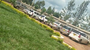 A parking lot with several cars and a grassy area with small plants. - Siaya Summit Hotel (Siaya)