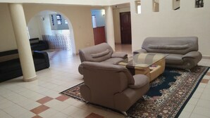 A spacious living room with two sofas, a glass coffee table, and a patterned rug. - Siaya Summit Hotel (Siaya)