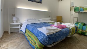 A hotel room with a bed, a chair, a lamp, and a bunk bed. - La Fattoria dei Sibillini (Montemonaco)