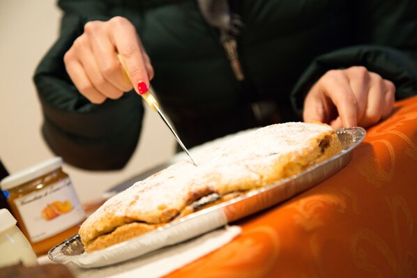 Una persona cortando un pastel con un cuchillo sobre una bandeja.