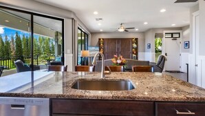 A modern kitchen with a granite countertop, stainless steel sink, and dark cabinetry. - ONE of Our BEST! Fresh Pricing, UPSCALE Renovations; (22V-1) where you get HUGE OCEAN Views (Lahaina)