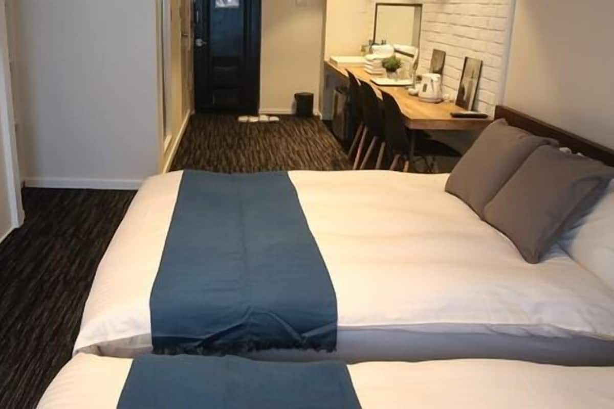 Een hotelkamer met twee bedden, een bureau en een spiegel.
