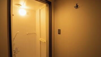 A bathroom with a shower, a towel rack, and a light fixture.