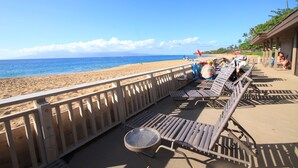 Eine Strandlounge mit Liegestühlen und Blick aufs Meer.
