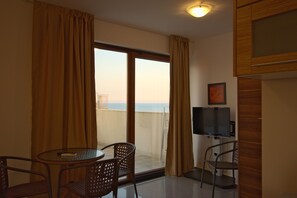 Monolocale, balcone, vista mare | Soggiorno | TV a schermo piatto 32 pollici con canali via cavo, TV, giocattoli