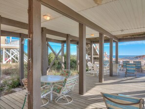 Relax on the outdoor patio with a round table and comfortable chairs amidst lush surroundings and ocean views.