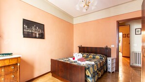 Un dormitorio con una cama de madera, una mesita de noche, un aparador y una fotografía de la ciudad en la pared.