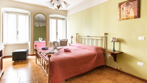Un dormitorio con cama, espejo, candelabro y un cuadro en la pared.