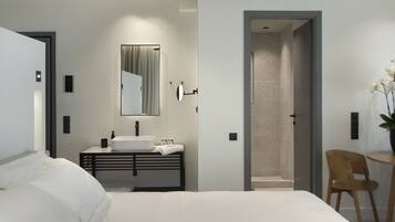 Une chambre moderne avec un grand lit, une table de chevet, un lavabo intégré et un miroir.