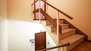 Un escalier avec des rampes et des marches en bois, menant à l’étage supérieur.