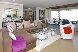 A modern living room with a glass coffee table, a sofa, and a dining area with chairs. - Terrezas 2 (Maspalomas)