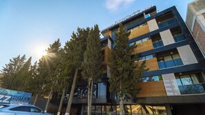 Un hôtel moderne, avec un bâtiment à plusieurs étages, de grandes fenêtres et une enseigne bien visible.