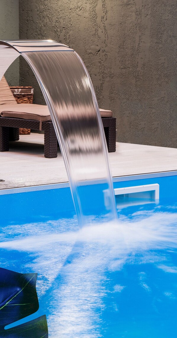 Relax by the pool surrounded by a deck and lounge chairs.