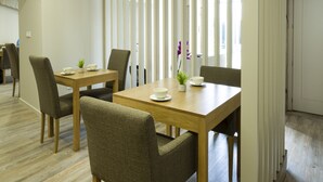 A modern conference room with a wooden table, chairs, and a ceiling with a perforated design. - Hospedaria Nossa Senhora do Carmo (Viana do Castelo)