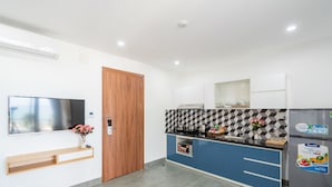 A modern kitchen with a built-in oven, a microwave, and a refrigerator. - Dandelion Apartment (Da Nang)