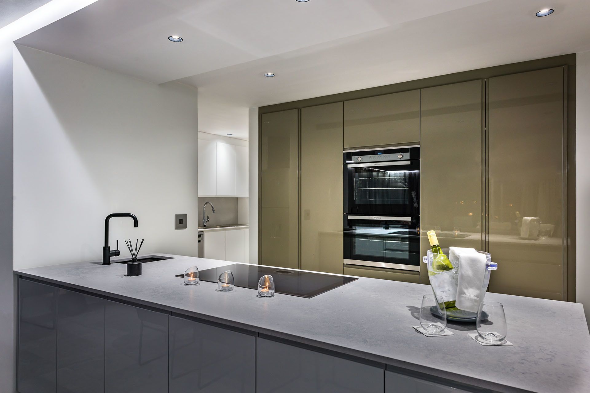 A modern kitchen with a sleek countertop, a built-in oven, and a wine cooler.