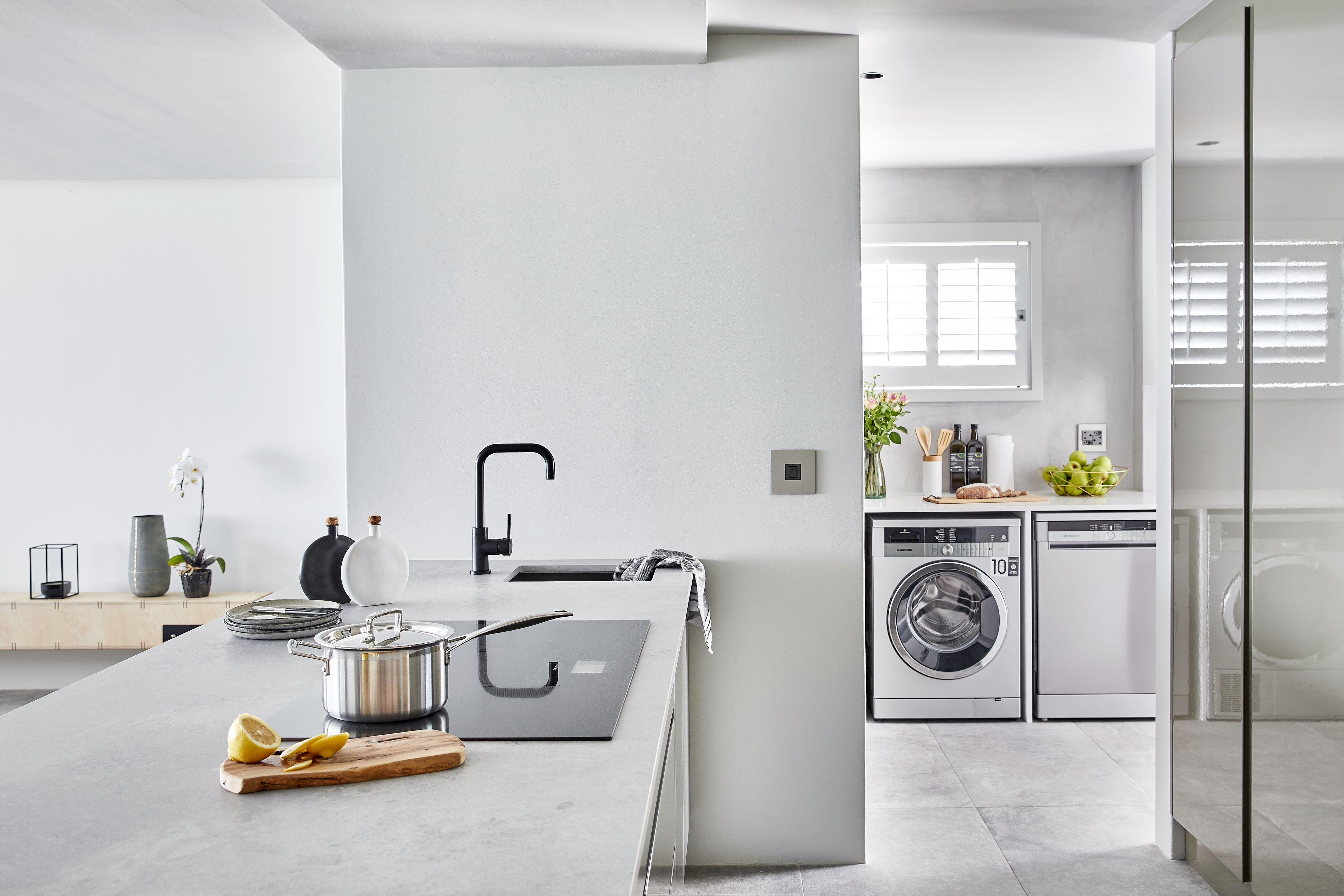 A modern kitchen with a large island, built-in appliances, and a minimalist design.
