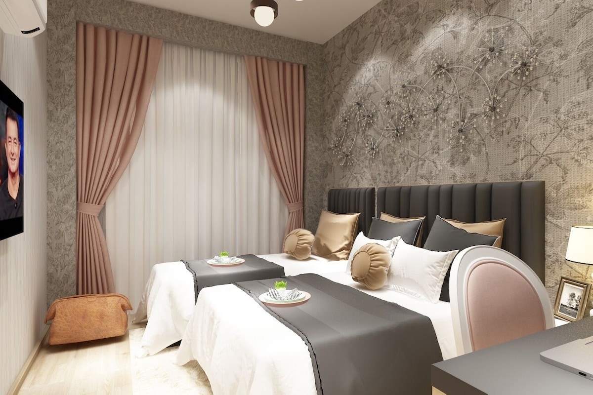 A hotel room with a large bed, two bedside tables, a desk, and a TV.