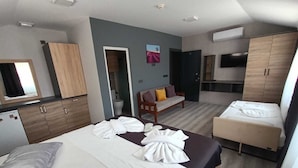 Et hotelværelse med seng, sofa, tekøkken og badeværelse.