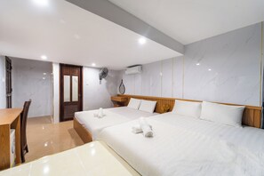 Une chambre d’hôtel avec deux lits, un bureau en bois, une chaise, une armoire en bois et un appareil de climatisation.