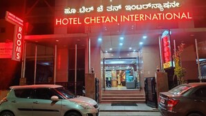 Hotel Chetan International com uma placa em inglês e outra língua local.