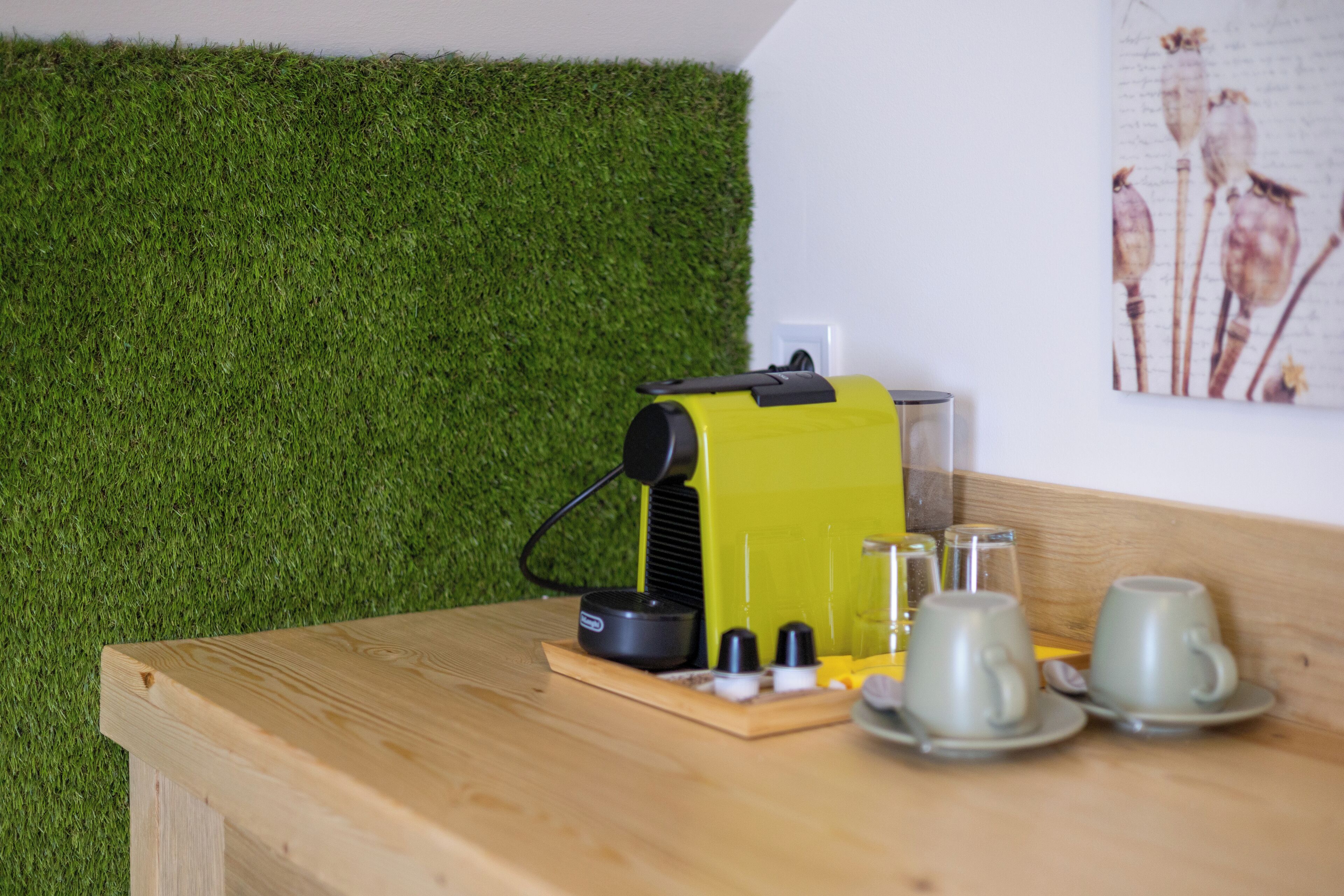 Una mesa de madera con un dispositivo amarillo, dos vasos y un pequeño recipiente.