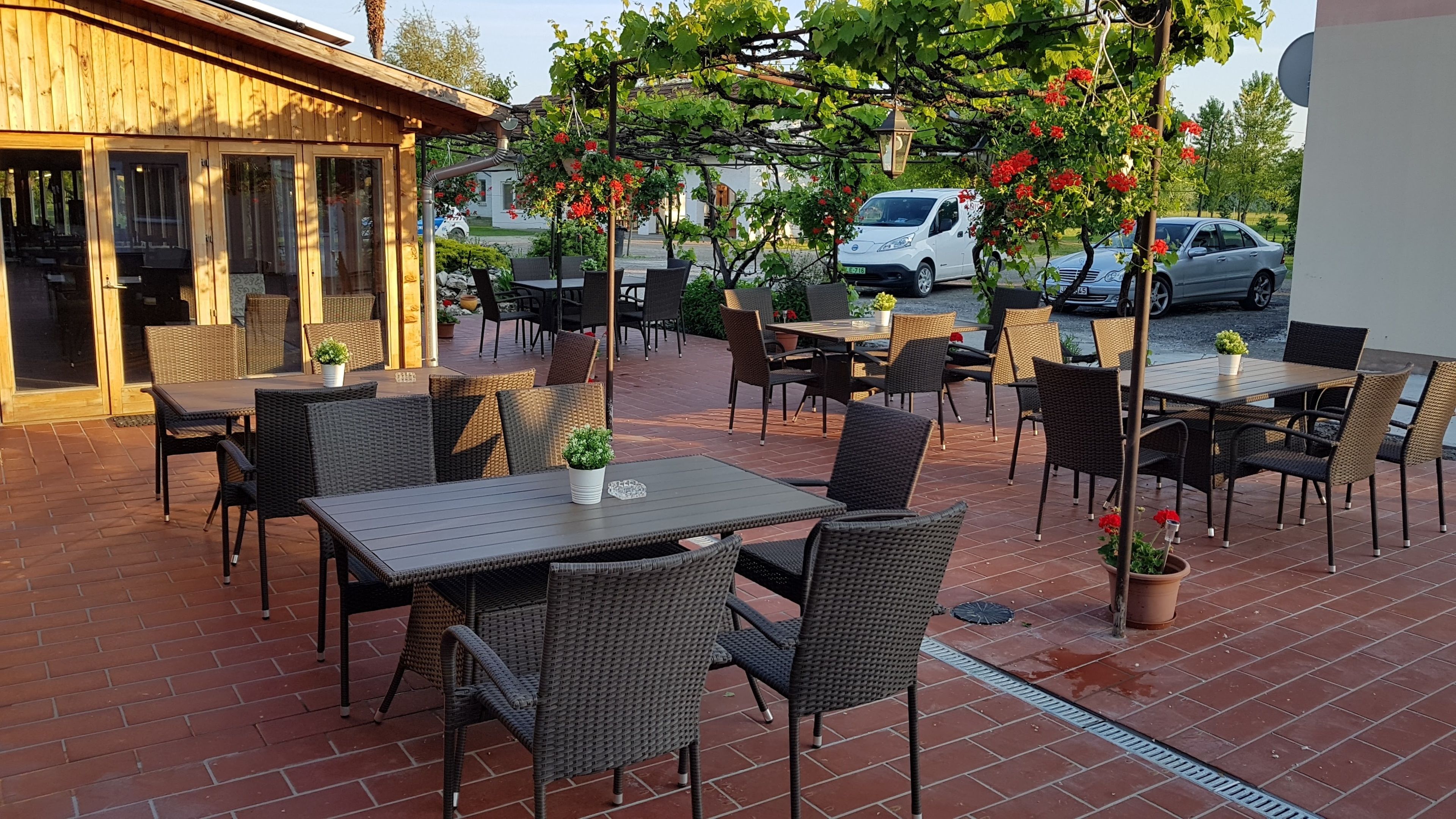 An outdoor patio with wicker furniture and potted plants.
