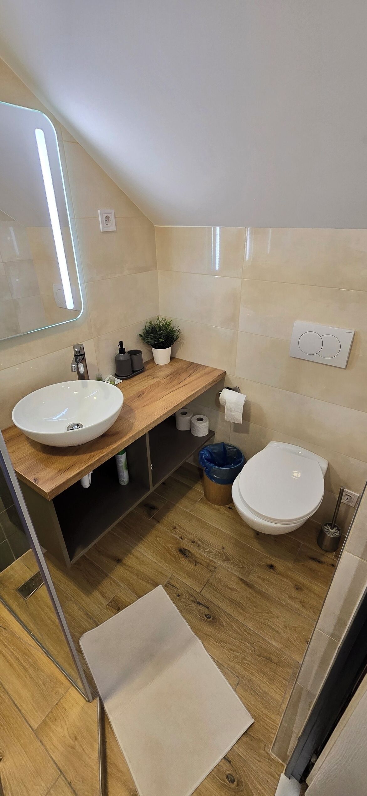 Un bagno moderno con due lavandini, un water e uno specchio con illuminazione integrata.
