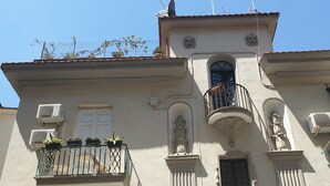 A building with a balcony, a door, and a window. - Lesuite Napoli (Naples)