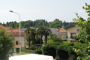 A residential area with stone buildings, a street lamp, and lush greenery.