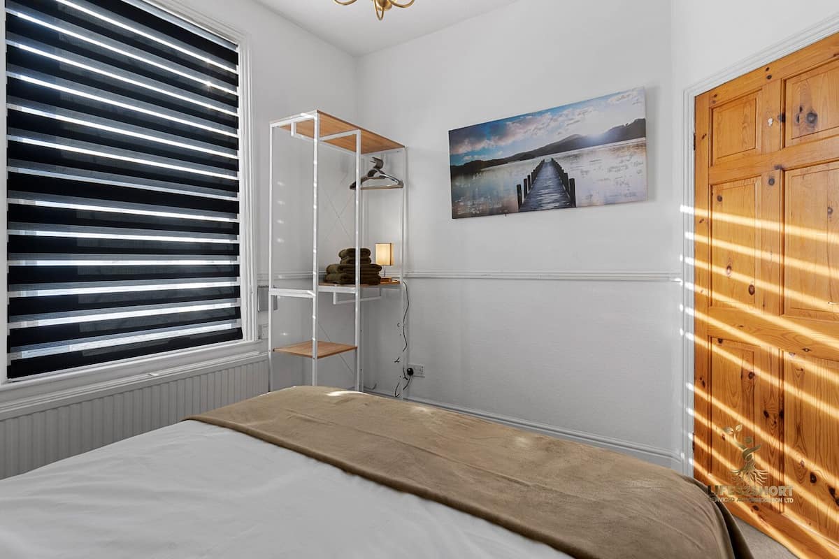 Um quarto com uma cama, um armário de madeira, uma estante de madeira e um quadro.