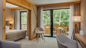 Une chambre d’hôtel comprenant un lit, un bureau, une chaise et un balcon avec une table et des chaises.