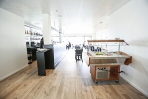 A modern hotel lobby with a bar area, a buffet setup, and a spacious seating area. - Hotel Tante Lemvig (Lemvig)